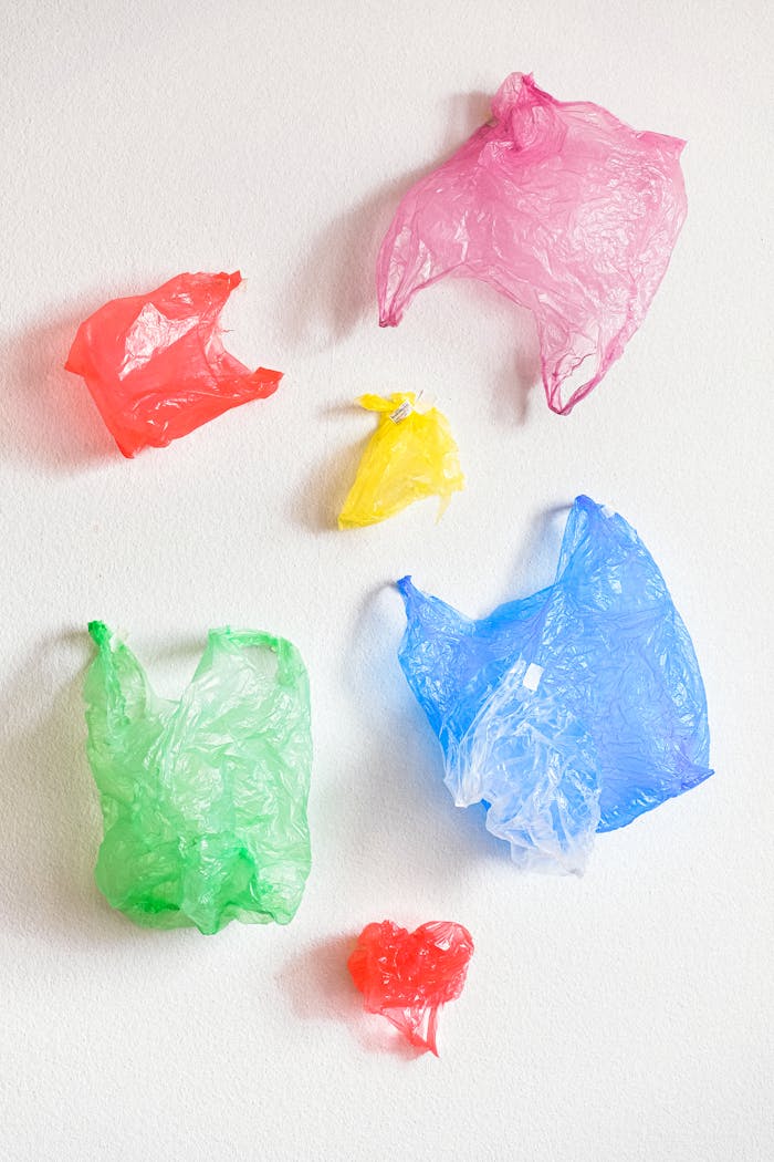 Artistic arrangement of colored plastic bags emphasizing recycling and pollution awareness.